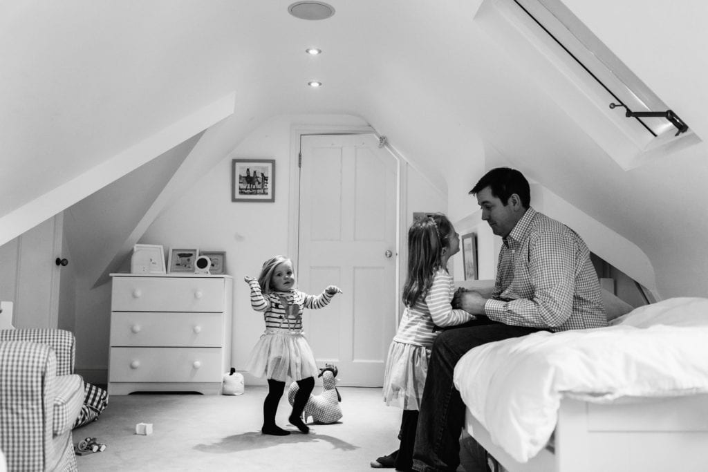Daughters and dad in their bedroom playing