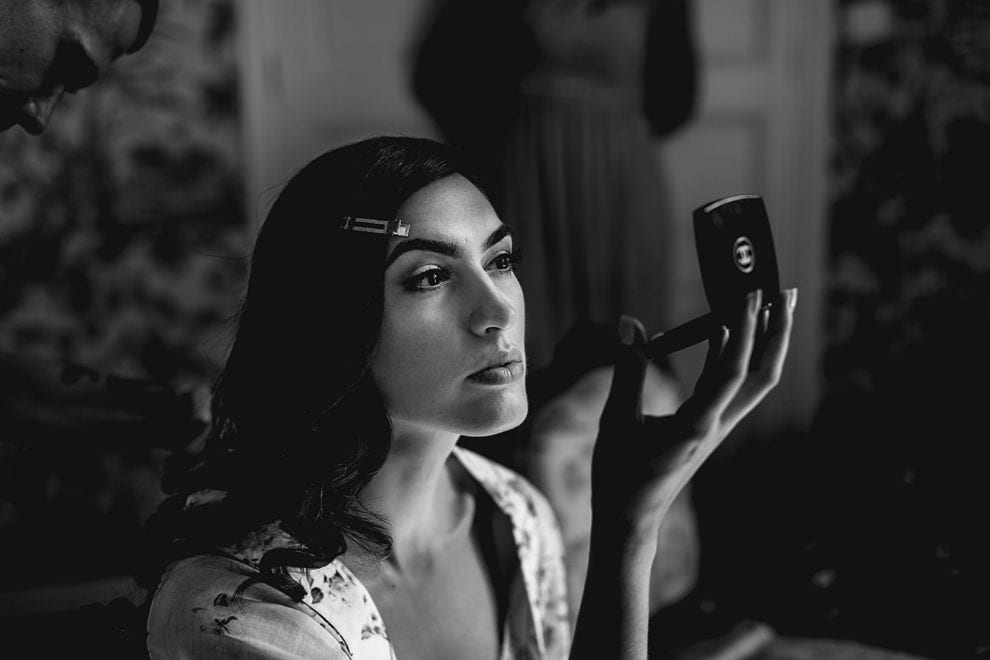 beautiful bride checks her make up while getting ready