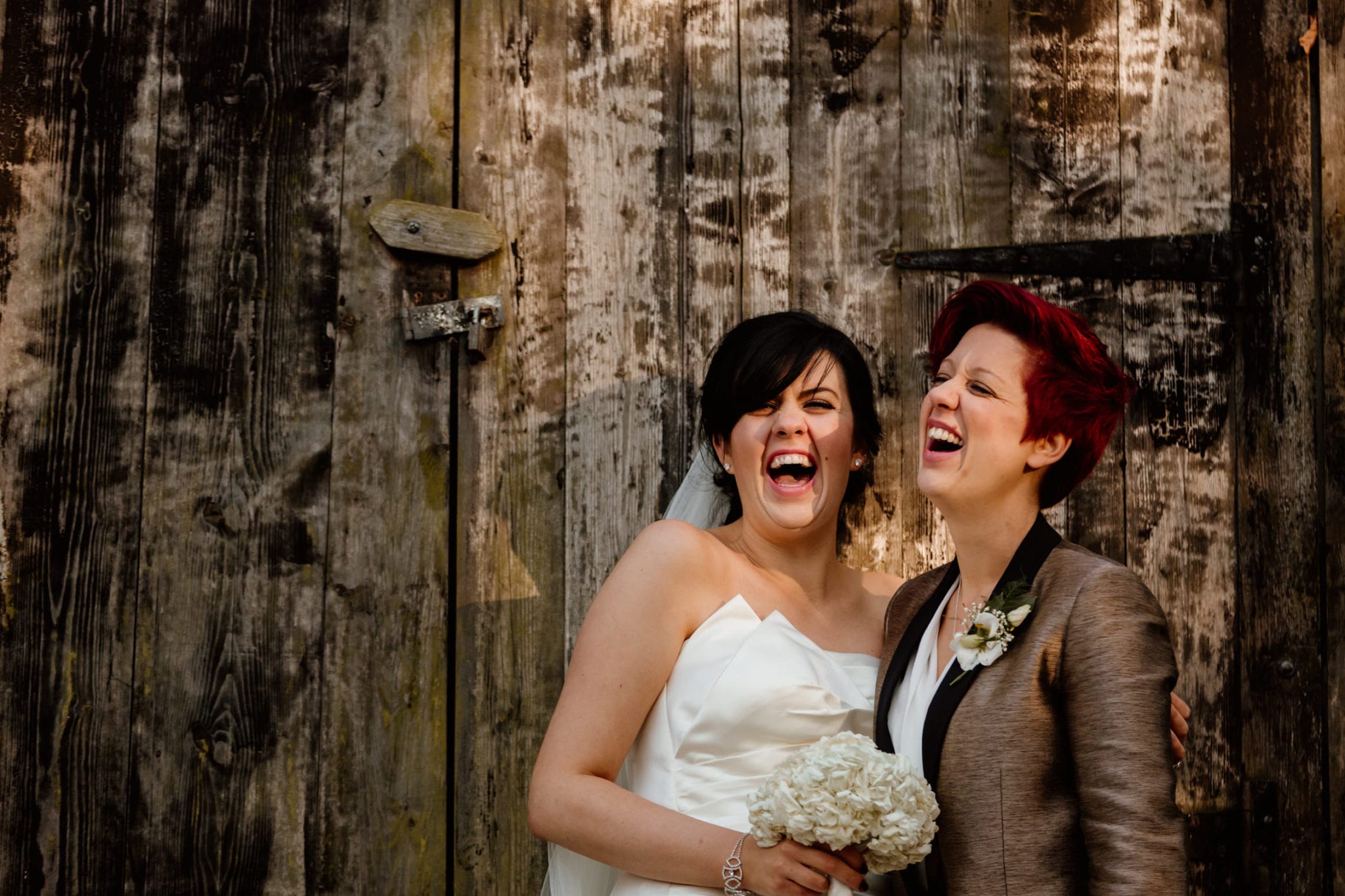 Two brides laughing at wedding