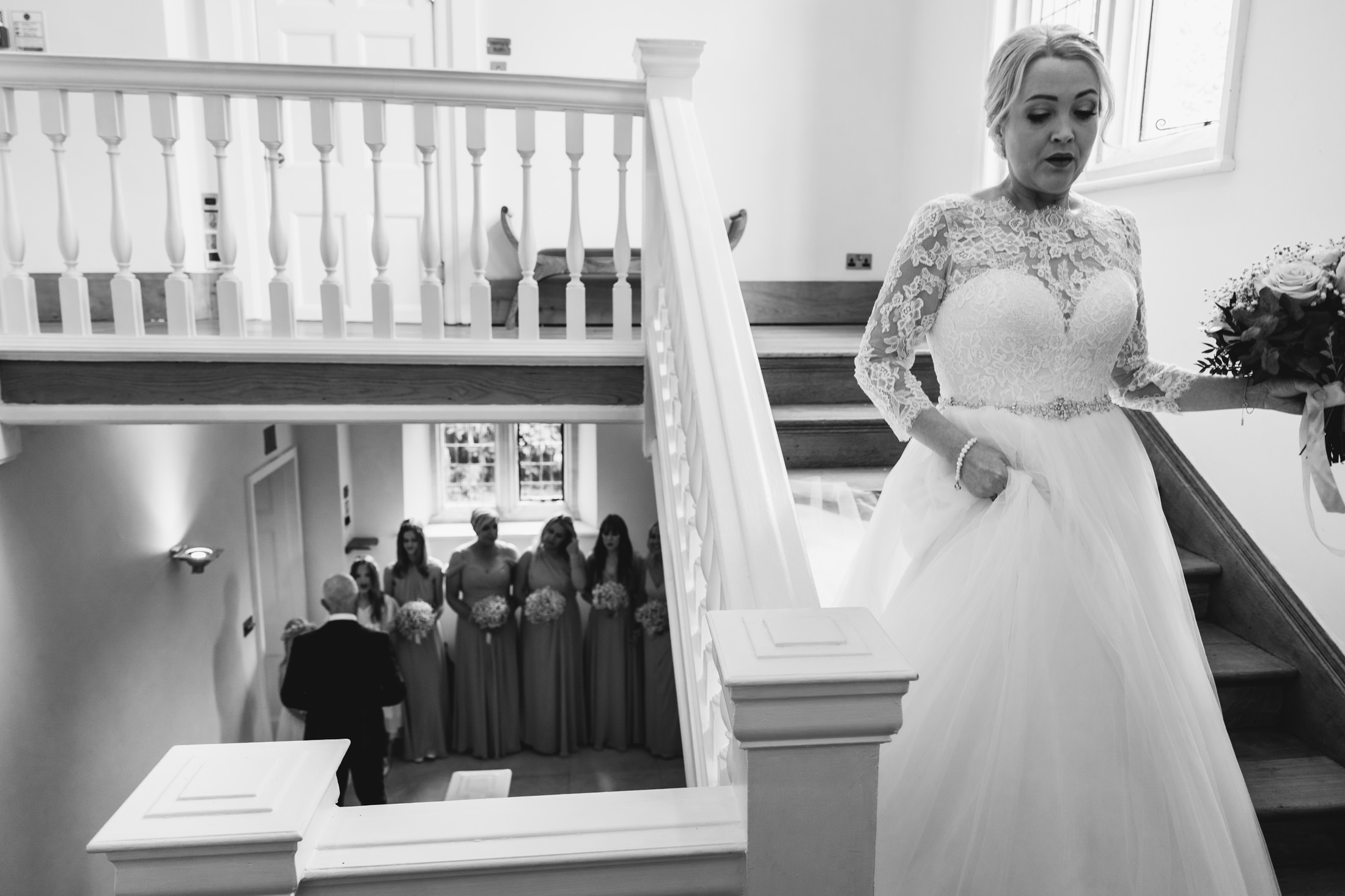 Bride coming down the stairs to meet her dad before wedding